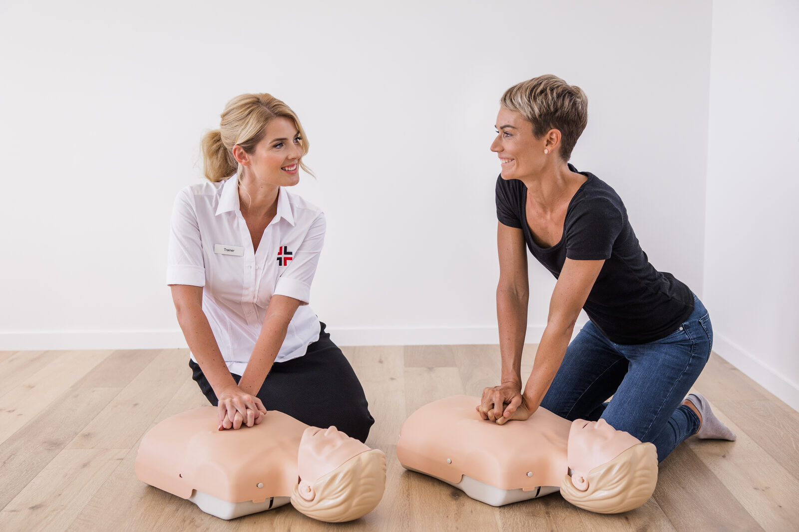 An Australia Wide First Aid trainer and a student practising CPR on training manikins